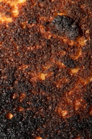 Eine sehr verbrannte Brotrolle Toast in Nahaufnahme Textur