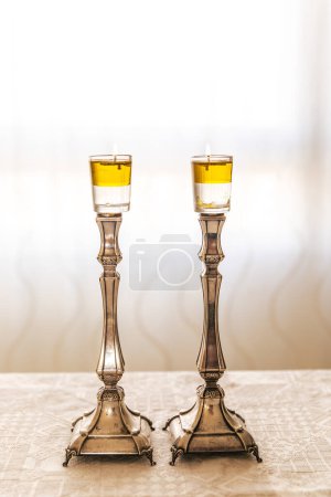 Photo for A pair of Shabbat candle with oil on silver candlesticks on the Shabbat table. - Royalty Free Image