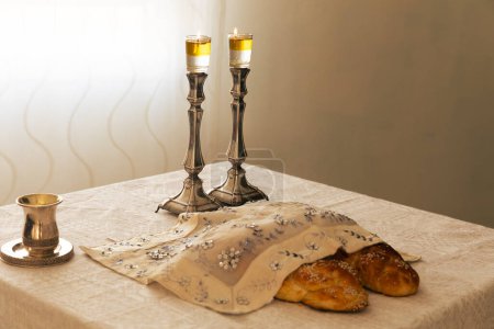 Photo for Shabbat image - silver candlesticks Lightened with olive oil, Silver kiddush cup and challah - Royalty Free Image