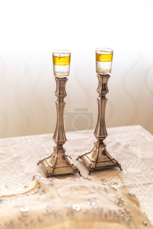 Photo for A pair of Shabbat candles with oil on silver candlesticks on the Shabbat table. - Royalty Free Image