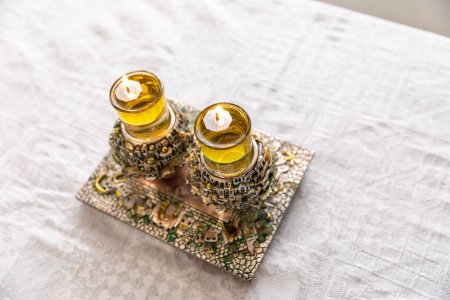 Photo for A pair of a special  Shabbat candlesticks with the city of Jerusalem engraved on them with oil, are lit on the Shabbat table. - Royalty Free Image