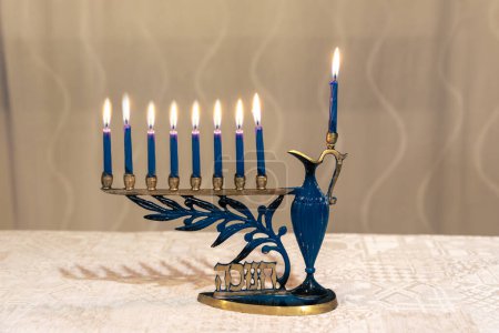 Photo for Beautiful Menorah (Chanukkiah) with 8 lit burning candles for Jewish Hanukkah holiday on table at home. Celebrating Chanukah festival of lights. - Royalty Free Image