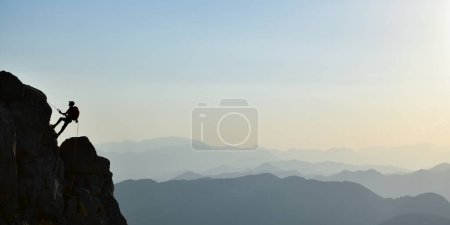 Photo for Young Man Doing Tough Rock Climbing - Royalty Free Image