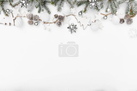 Téléchargez les photos : Joyeux Noël guirlande faite de branches de sapin des neiges, cônes, baies, étoiles sur fond blanc. Bonne année et Noël, vue de dessus - en image libre de droit