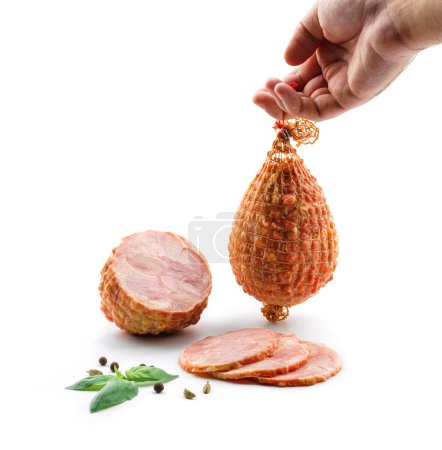 Photo for Hand holding a stick of boiled pork sausage. Sliced smoked ham, gammon with spices and fresh herbs isolated on white background. Meat boiled sausage, top view - Royalty Free Image