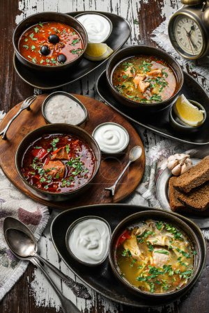 Foto de Sopa de pollo, sopa de pescado con salmón, sopa hodgepodge con carne, sopa de remolacha en la mesa de madera rústica. Comida sana, de cerca - Imagen libre de derechos