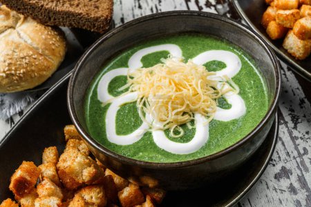 Photo for Vegan spinach soup with cheese, sour cream and croutons in bowl on rustic wooden background. Close up - Royalty Free Image