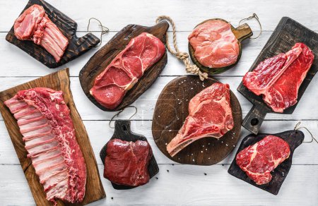 Photo for Set of various raw meat steaks. Fresh meat of beef, pork, veal, chicken, steak t-bone, rib eye, tomahawk, ribs, tenderloin on cutting board over white background. Meat food, butcher shop, top view - Royalty Free Image
