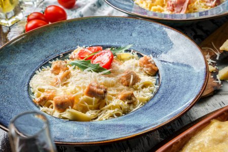 Foto de Pasta con queso parmesano, atún y tomates sobre fondo de madera con servilleta. Comida italiana, primer plano - Imagen libre de derechos