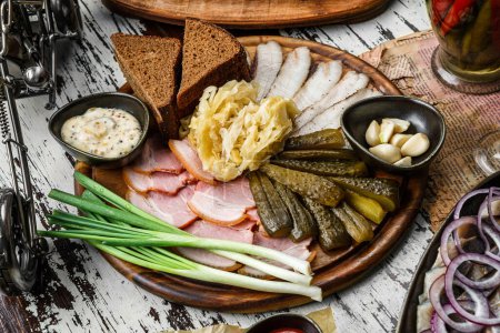 Photo for Sliced ham, bacon, lard, pickles, green onions, slices of rye bread on cutting board over rustic background. Appetizer for vodka, close up - Royalty Free Image