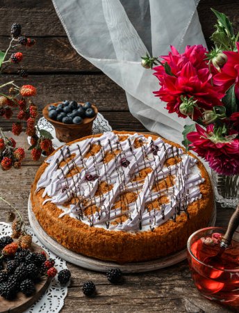 Photo for Delicious biscuit cake with cream and berries on wooden rustic background with cup of tea, flowers, lace napkins. Sweets, dessert and pastry, homemade cakes, top view - Royalty Free Image