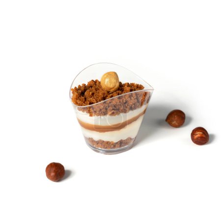 Photo for Cheesecake mousse pudding with caramel and hazelnuts in glass cup on white background. Candy bar, sweets and dessert, selective focus - Royalty Free Image
