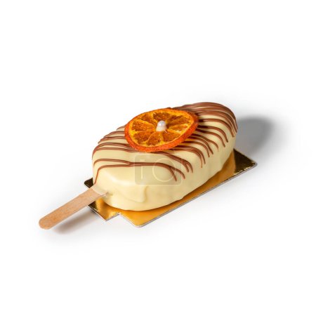 Téléchargez les photos : Crème glacée glacée au chocolat blanc sur bâton avec tranche d'orange sèche isolée sur fond blanc. Bonbons, bonbons et desserts - en image libre de droit