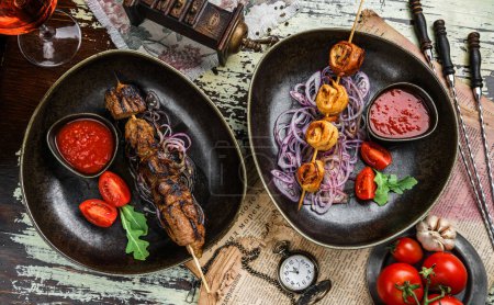 Photo for Grilled meat shish on skewers with vegetables and tomato sauce on the plate. Healthy food. Hot meat dishes, kebab food, top view - Royalty Free Image