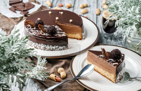 Photo for Delicious mousse cake with chocolate glaze, coconut, cream and nuts on grey background with plants and cup of coffee. Sweets, dessert and pastry, top view - Royalty Free Image
