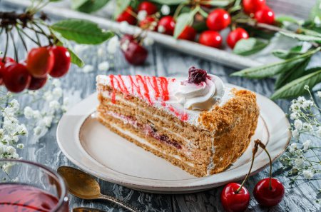 Photo for Piece of delicious cake with cream and jam from cherry on the plate over grey background with fresh cherries on branch. Sweets, dessert and pastry, close up, selective focus - Royalty Free Image
