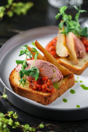 Foto de Sándwiches con paté de carne, verduras, rebanadas de pera y microverduras en el plato sobre la mesa con bebidas. Comida saludable para el desayuno, vista superior - Imagen libre de derechos