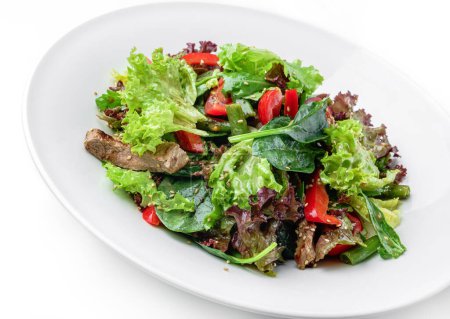 Téléchargez les photos : Salade saine avec viande de bœuf grillée, tomates, poivron, laitue, roquette, haricot français et sauce dans une assiette isolée sur fond blanc. Alimentation saine, vue de dessus - en image libre de droit