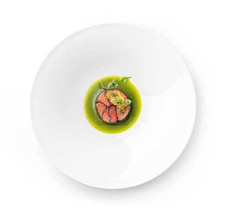 Foto de Filete de pescado salmón con caviar de pescado y salsa en plato aislado sobre fondo blanco. Mariscos, plano, vista superior - Imagen libre de derechos