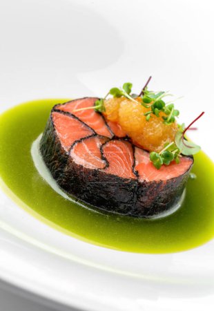 Foto de Filete de pescado salmón con caviar de pescado y salsa en plato aislado sobre fondo blanco. Mariscos, de cerca, vista superior - Imagen libre de derechos