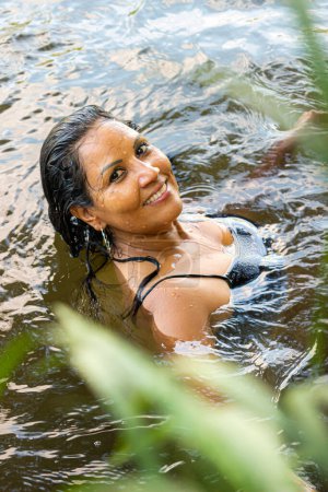 Hispanic woman submerged in a river in southern Colombia