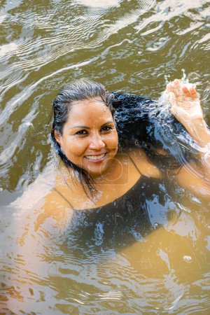 Latin woman swimming in a river in southern Colombia
