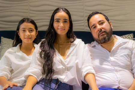 Téléchargez les photos : Portrait d'une famille latine colombienne assise sur un canapé bleu à Neiva - Huila - Colombie - en image libre de droit