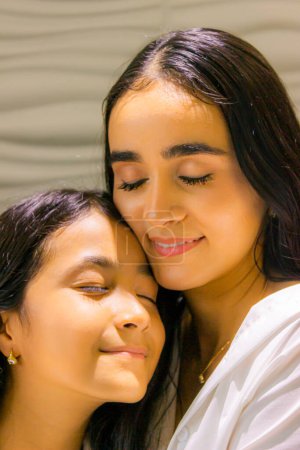 Latina Mutter umarmt ihre hispanische Tochter mit Liebe
