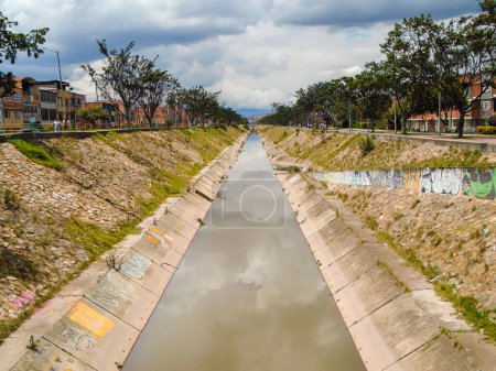 Téléchargez les photos : Canal d'eau avec arbres verts dans un quartier de Bosa, Bogota - Colombie - en image libre de droit