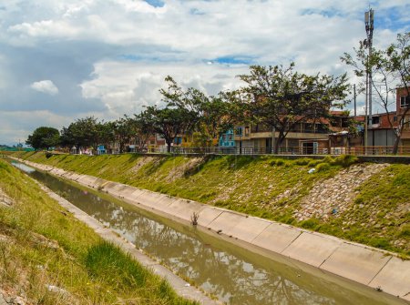Téléchargez les photos : Canal d'eau avec arbres verts dans le quartier El Porvenir à Bosa, au sud de Bogota - Colombie - en image libre de droit