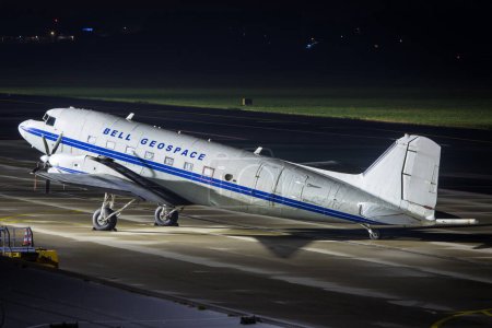Téléchargez les photos : Graz, Autriche - 18 novembre 2021 : Un Basler BT-67, ancien Douglas DC-3, avion à hélice de l'institut de recherche Bell Geospace stationné la nuit sur le tablier à Graz, Autriche - en image libre de droit