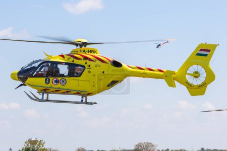 Photo for Fertzentmiklos, Hungary - April 30, 2023: Rescue helicopter H135 of OMSZ Lgiment, Hungarian Air Ambulance coming in for landing - Royalty Free Image