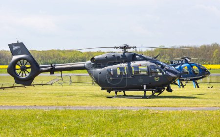 Foto de Fertzentmiklos, Hungría - 30 de abril de 2023: Helicóptero H45M de la Fuerza Aérea Húngara junto con el helicóptero MD-500E de la Policía de Hungría en tierra - Imagen libre de derechos