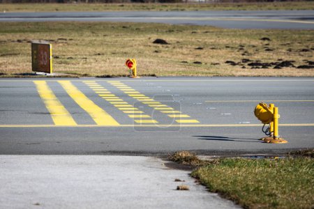 Stop bars on a airport taxiway at the holding point before entering the runway.