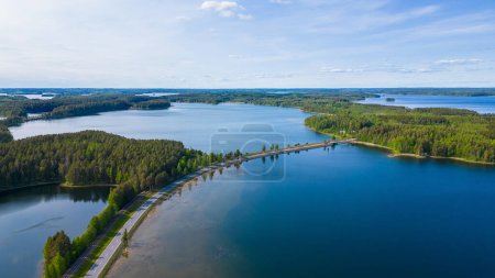 Typisch finnische Landschaft mit blauen Seen, Wald und einer malerischen Straße