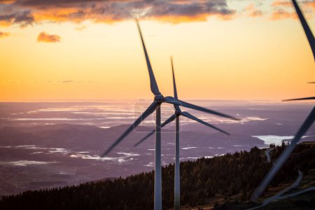 Windkraftanlage bei Sonnenaufgang auf einem Berg in Österreich drehen