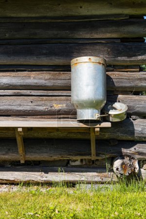 Milk can drying in the sun at a log cabin of a traditional dairy farm
