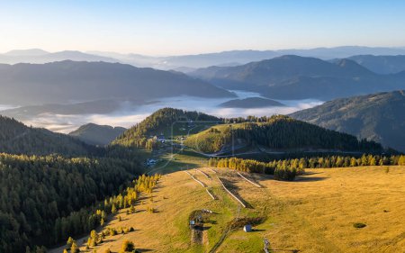 Idyllische Alm Bürgeralm in der Steiermark, Österreich an einem schönen Herbstmorgen mit Nebel im Tal und warmem Sonnenlicht. Reiseziel in Österreich.