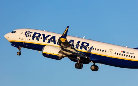 Photo for Salzburg, Austria - January 27, 2024: Ryanair aeroplane Boeing 737MAX taking off in beautiful evening light - Royalty Free Image