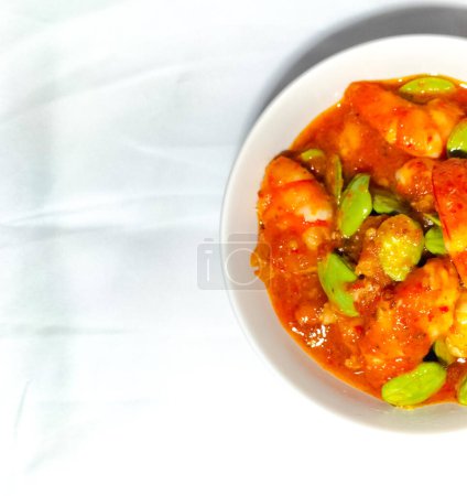Photo for Selective focus. Chili prawns or Sambal Udang with petai or pete in white plate on white background. Indonesia cuisine food. - Royalty Free Image
