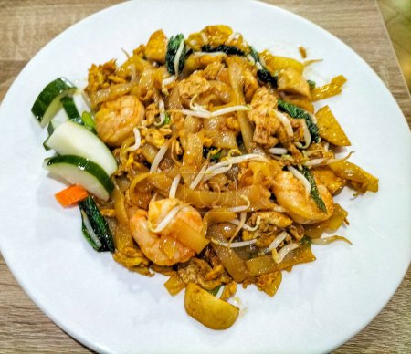 Selective focus. Stir fried flat rice noodle or char kway teow that is famous among Indonesian as breakfast or another meal. Chinese cuisine. Seafood stir fried.