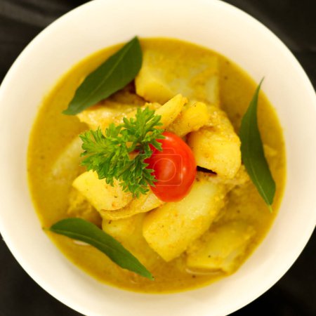 Gulai Cumi or Squid cooked yellow seasoning with coconut milk. Specialties Padang, West Sumatra Indonesia. Selective focus.