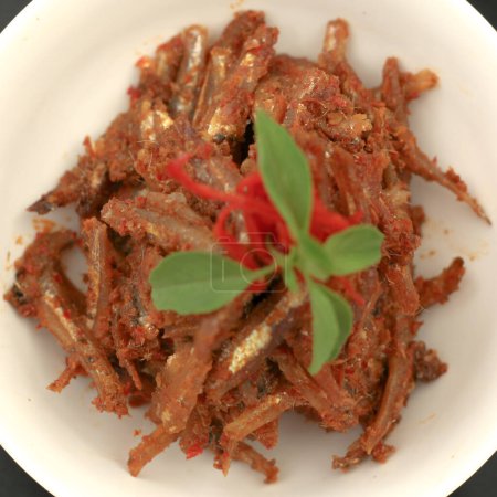 Téléchargez les photos : Sambal balado teri est un anchois frit avec une sauce chili chaude et épicée.Nourriture traditionnelle indonésienne. Gros plan. - en image libre de droit
