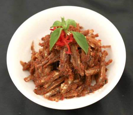 Téléchargez les photos : Sambal balado teri est un anchois frit avec une sauce chili chaude et épicée.Nourriture traditionnelle indonésienne. Gros plan. - en image libre de droit