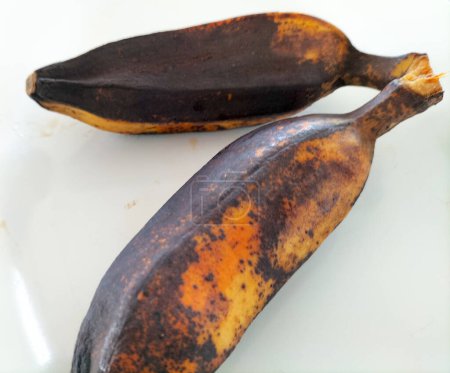 Mehrere gekochte Saba-Bananen werden auf einen weißen Teller gelegt. Asiaten essen gerne gekochte Bananen mit heißen Getränken zum Frühstück.