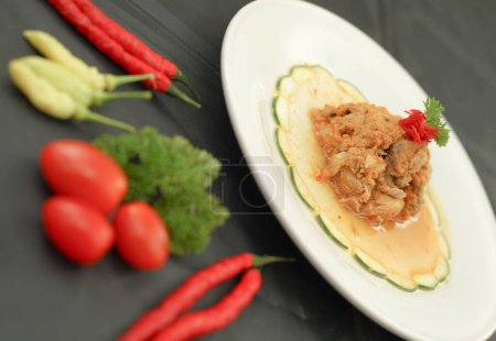 Téléchargez les photos : Cakalang Rica - Alimentation spéciale de Manado Indonésie, à base de poisson Skipjack cuit dans un Sambal aromatique épicé. Servi sur assiette blanche. Vue latérale. - en image libre de droit