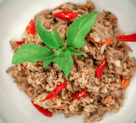 Würziger zerfetzter Thunfisch ist eine indonesische Speise. Es besteht aus geräuchertem Fisch, Chilischoten, Gewürzen und Kräutern. Weißer Hintergrund. Selektiver Fokus.
