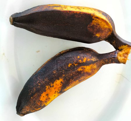 Plusieurs bananes Saba bouillies sont placées sur une assiette blanche. Asiatiques aiment manger des bananes bouillies avec des boissons chaudes pour le petit déjeuner.