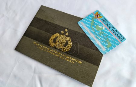 Selective focus. 1 sheets of ID card of the Republic of Indonesia above the motorized vehicle owner book (BPKB).  Tegal City, Indonesia.