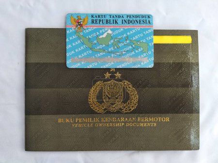 Selektiver Fokus. 1 Blatt Personalausweis der Republik Indonesien über dem Fahrzeugbesitzerbuch (BPKB). Tegal City, Indonesien.